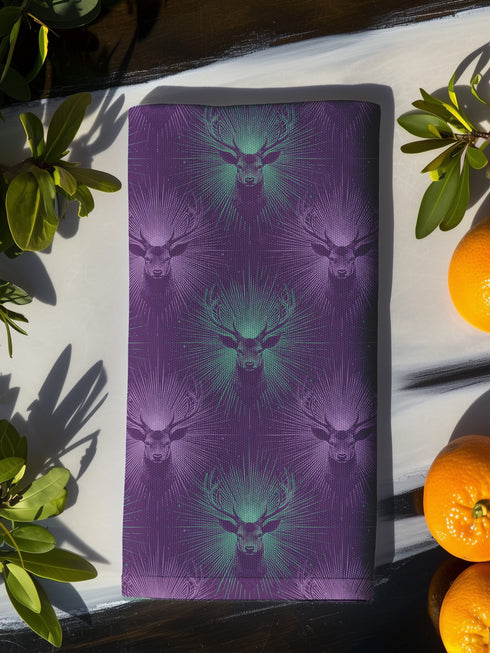 Set of four purple dining napkins featuring alternating teal and violet stag heads with radiating sunburst patterns, sized 18x18 inches.